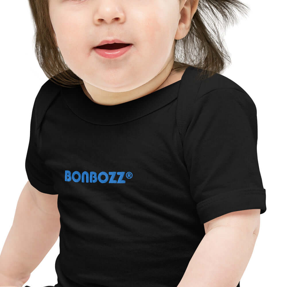 Kurzärmliger Baby-Einteiler N°0 aus Baumwolle mit Umschlagausschnitt, Druckknöpfen und fröhlichem Design.