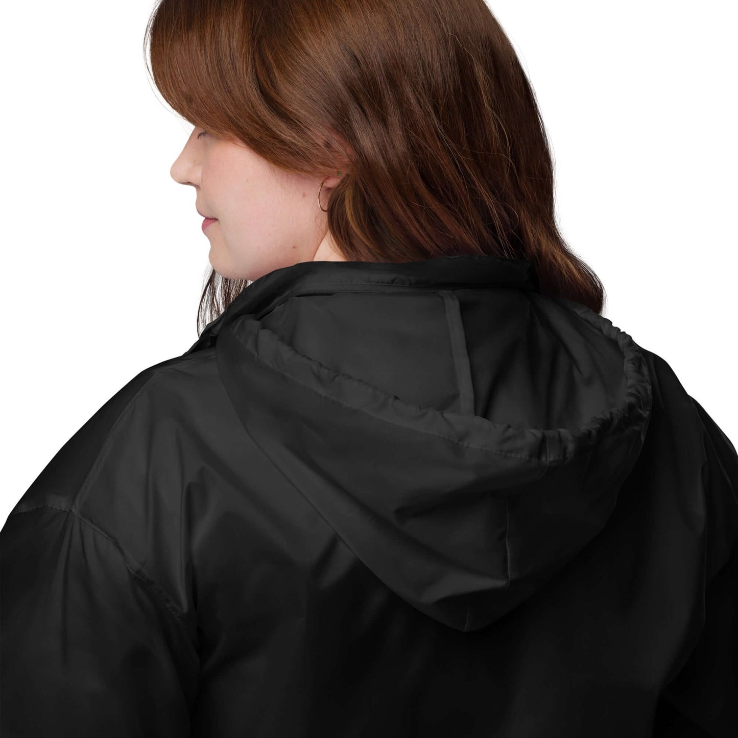 Woman wearing Basic-Unisex-Windbreaker N°0 in black showing hood and side profile, ideal for outdoor activities.