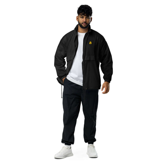 Man wearing Basic-Unisex-Windbreaker N°0 in black, showcasing durable, water-repellent design with zip closure and elastic cuffs.