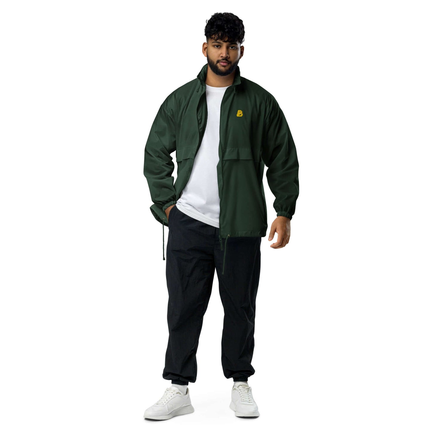 Man wearing Basic-Unisex-Windbreaker N°0 in forest green with elastic cuffs, full zip, and white sneakers, perfect for outdoor activities.