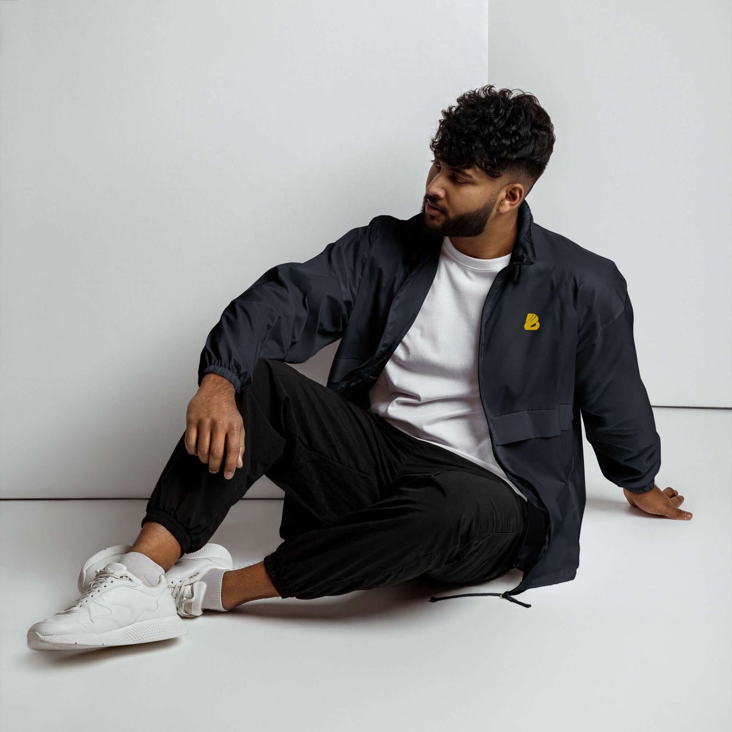 Model wearing Basic-Unisex-Windbreaker N°0, a lightweight, durable, and water-resistant jacket with elastic cuffs and front zipper.