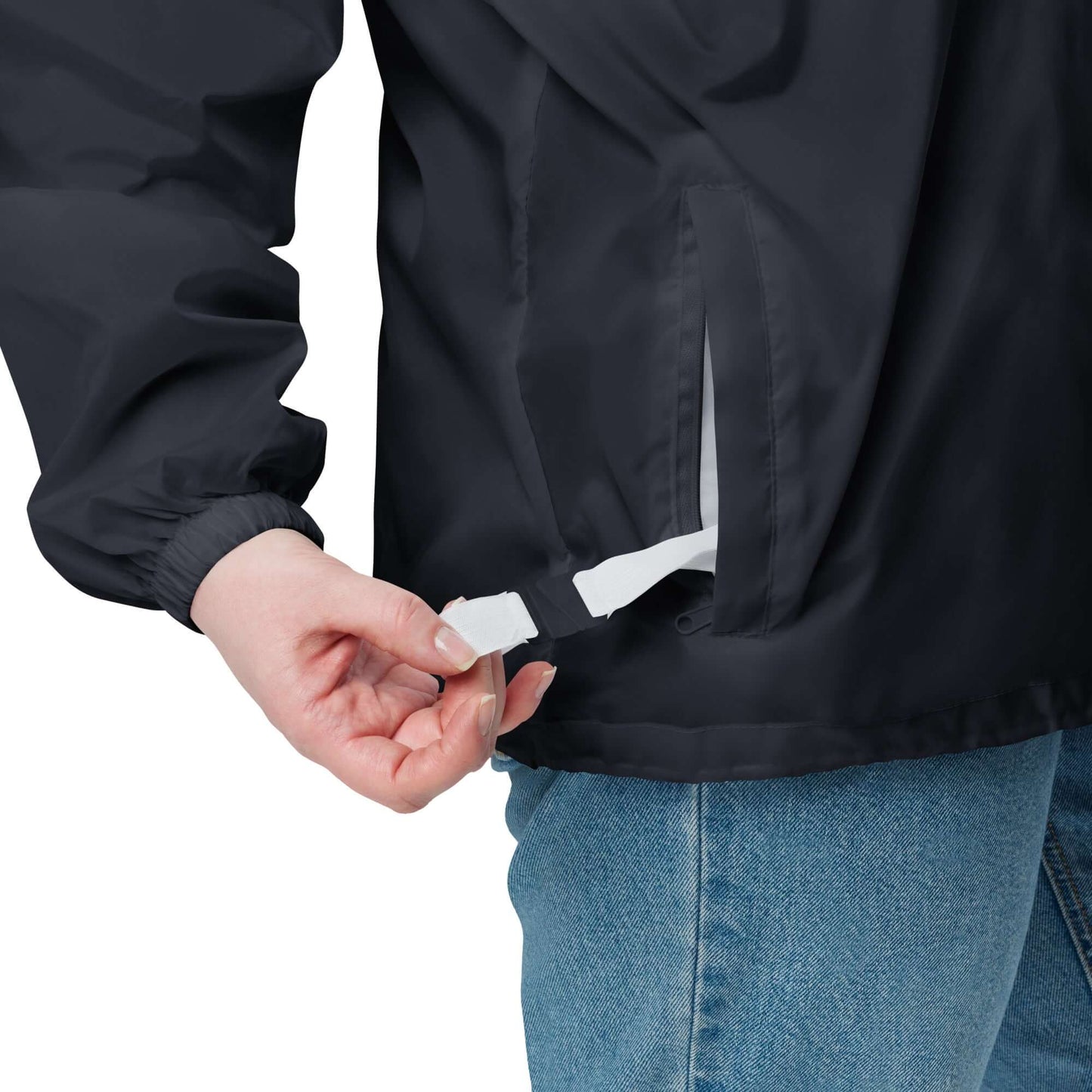 Person wearing Basic-Unisex-Windbreaker N°0 adjusting strap, showing durable, water-resistant material and front zipper.