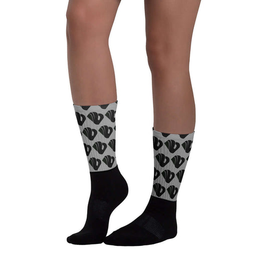 Person wearing Socken N°8 with black foot and vibrant pattern. Features cushioned sole and ribbed leg. Ideal for comfort and style.