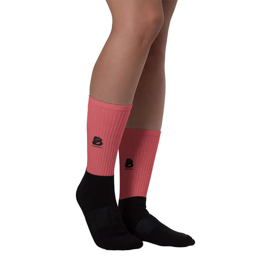Person wearing Socken N°0 with black foot and vibrant pink ribbed leg design, showcasing comfort and style.