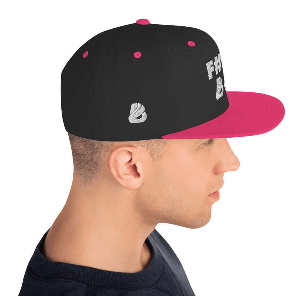 Man wearing Snapback-Cap N°2 with black and pink design, featuring a flat brim and adjustable snap closure.