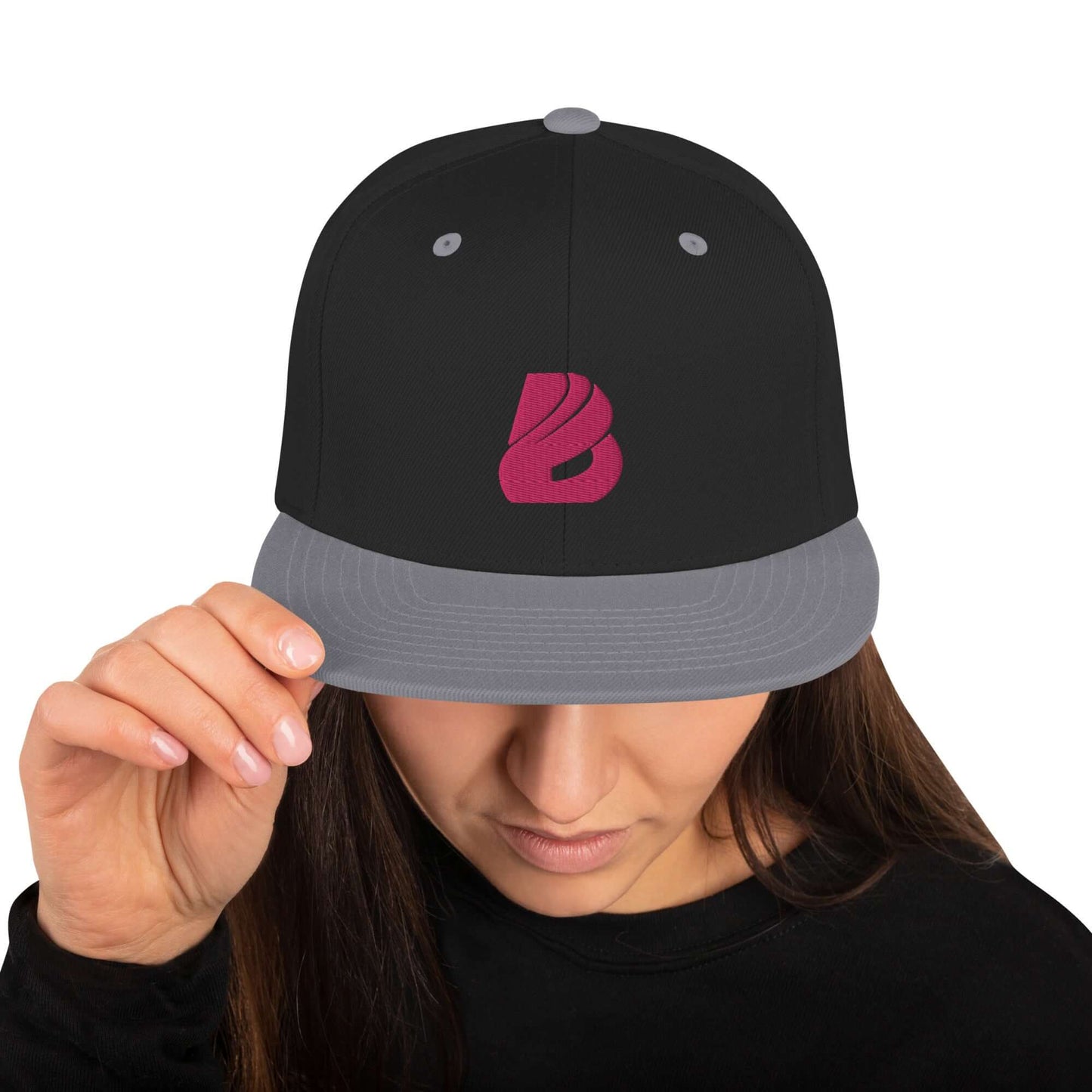 Snapback-Cap N°3 with classic fit, flat visor, adjustable snap closure, worn by woman, black and grey design with logo