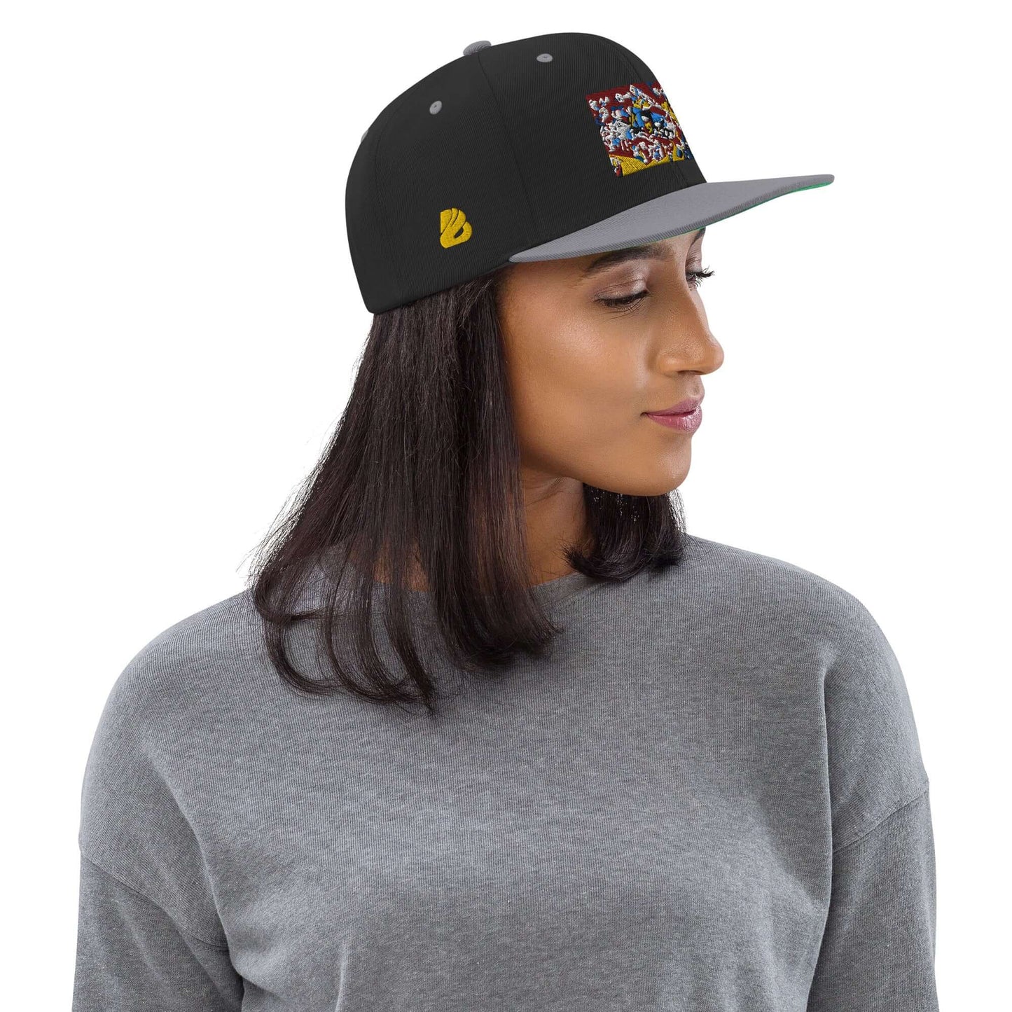 Woman wearing Snapback-Cap N°4 with black and gray color, featuring a flat brim and embroidered logo, ideal for casual fashion.