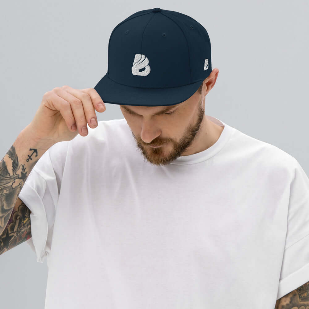 Man wearing Snapback-Cap N°1 with classic fit and flat brim, adjustable snap closure, blue color.