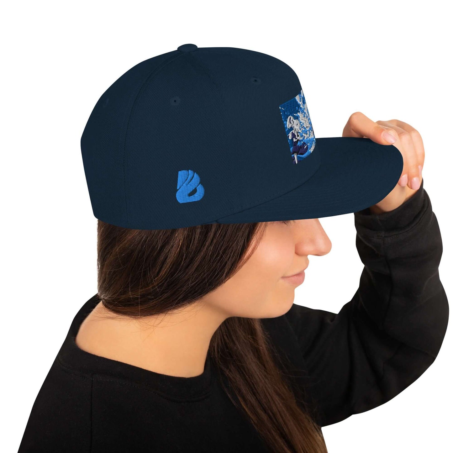 Snapback-Cap N°5 with classic fit, flat brim, and snap closure, worn by a woman. High-profile design with embroidered eyelets.