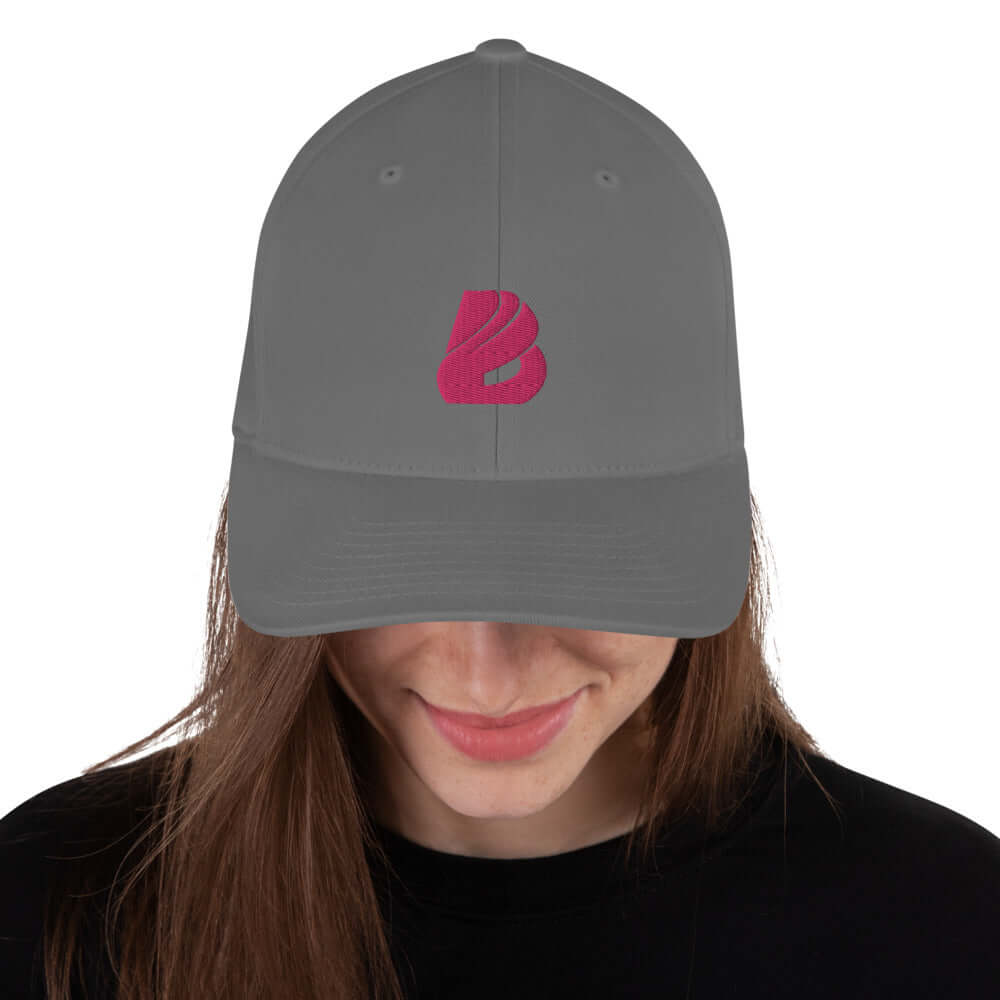 Strukturierte Cord-Cap N°0 in grey with pink logo on a person, showcasing a mid-profile structured design with a silver under visor.