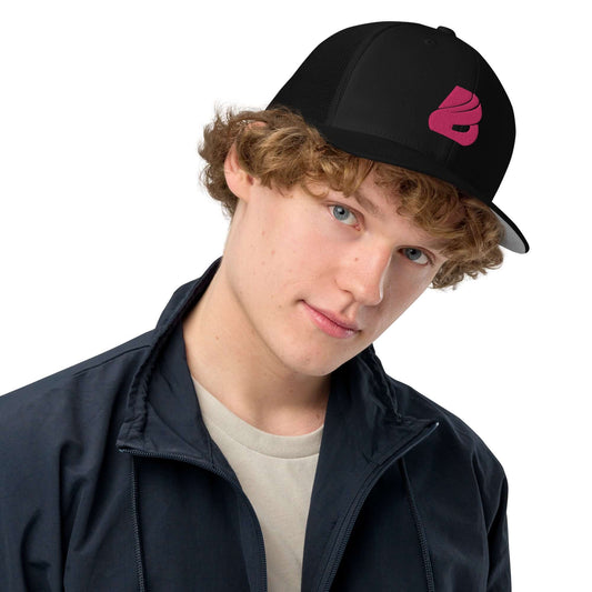 Junger Mann trägt Trucker-Cap mit geschlossener Rückseite N°0, schwarz mit pinkem Logo, passend zu Streetwear und Loungewear.