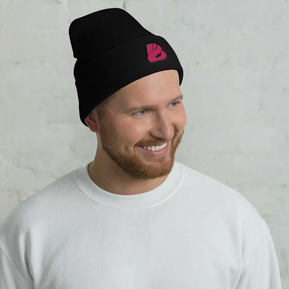Man wearing Umgeschlagene Beanie N°1 in black, snug fit, warm and stylish, with pink logo, unisex beanie, 100% Turbo-Acryl.