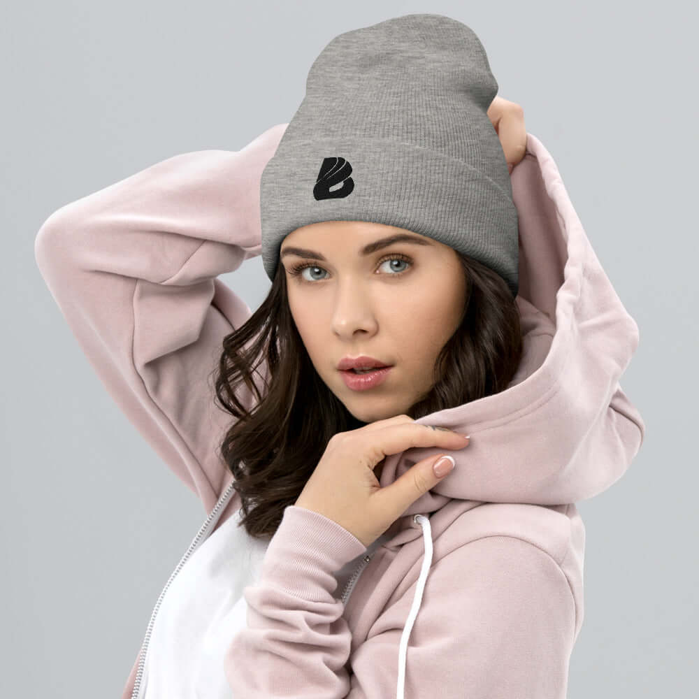 Woman wearing Umgeschlagene Beanie N°0 in gray, showcasing cozy and stylish unisex design, perfect for warmth and charm, in a pink hoodie.