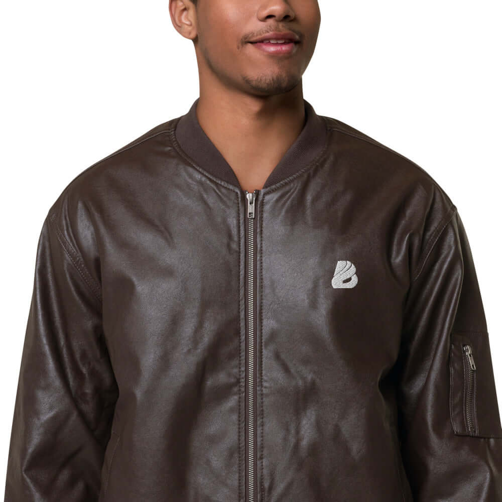 Model wearing Leder-Bomberjacke N°0 in dark brown PU leather with embroidered logo and ribbed collar.