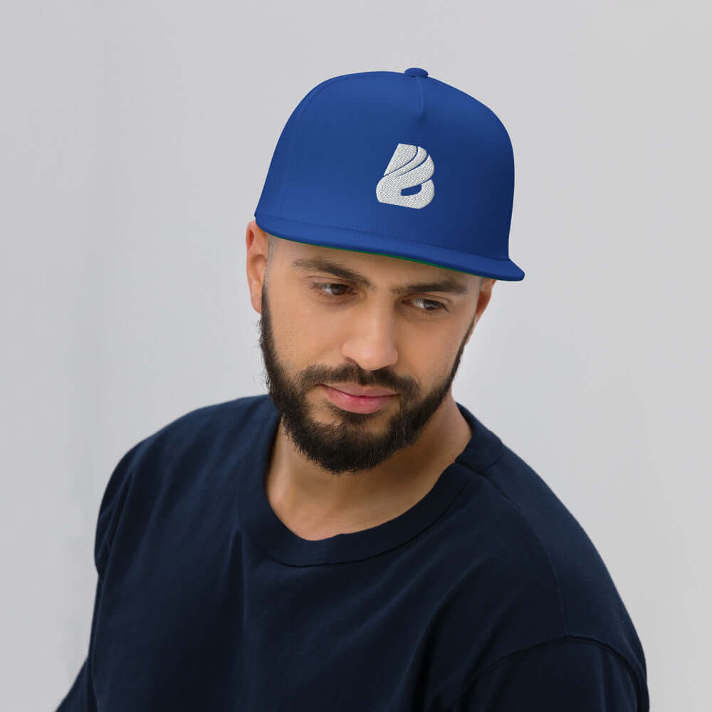 Flat Bill-Cap N°0 in blue with green underbill and structured design, showcased on a model, featuring snapback closure and 5-panel construction.