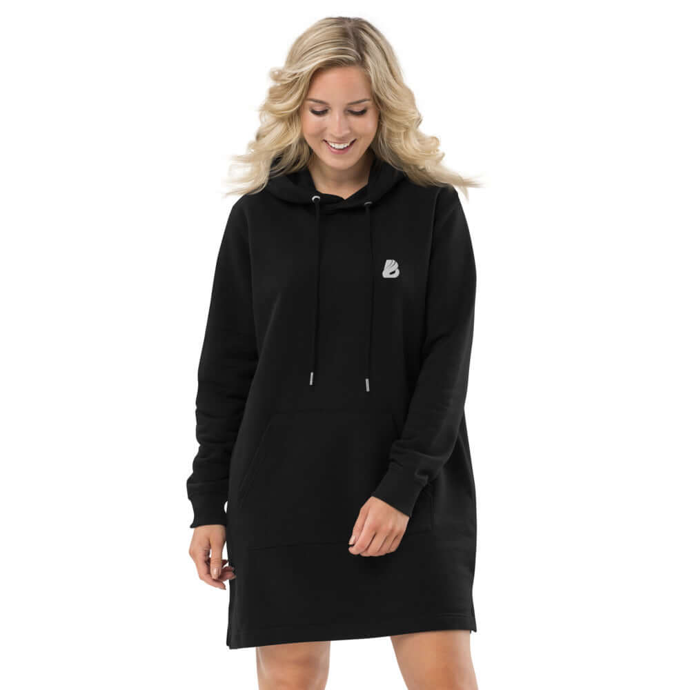Woman wearing Hoodiekleid N°1 black hoodie dress made from organic cotton and recycled polyester, featuring comfortable fit and double-layered hood.