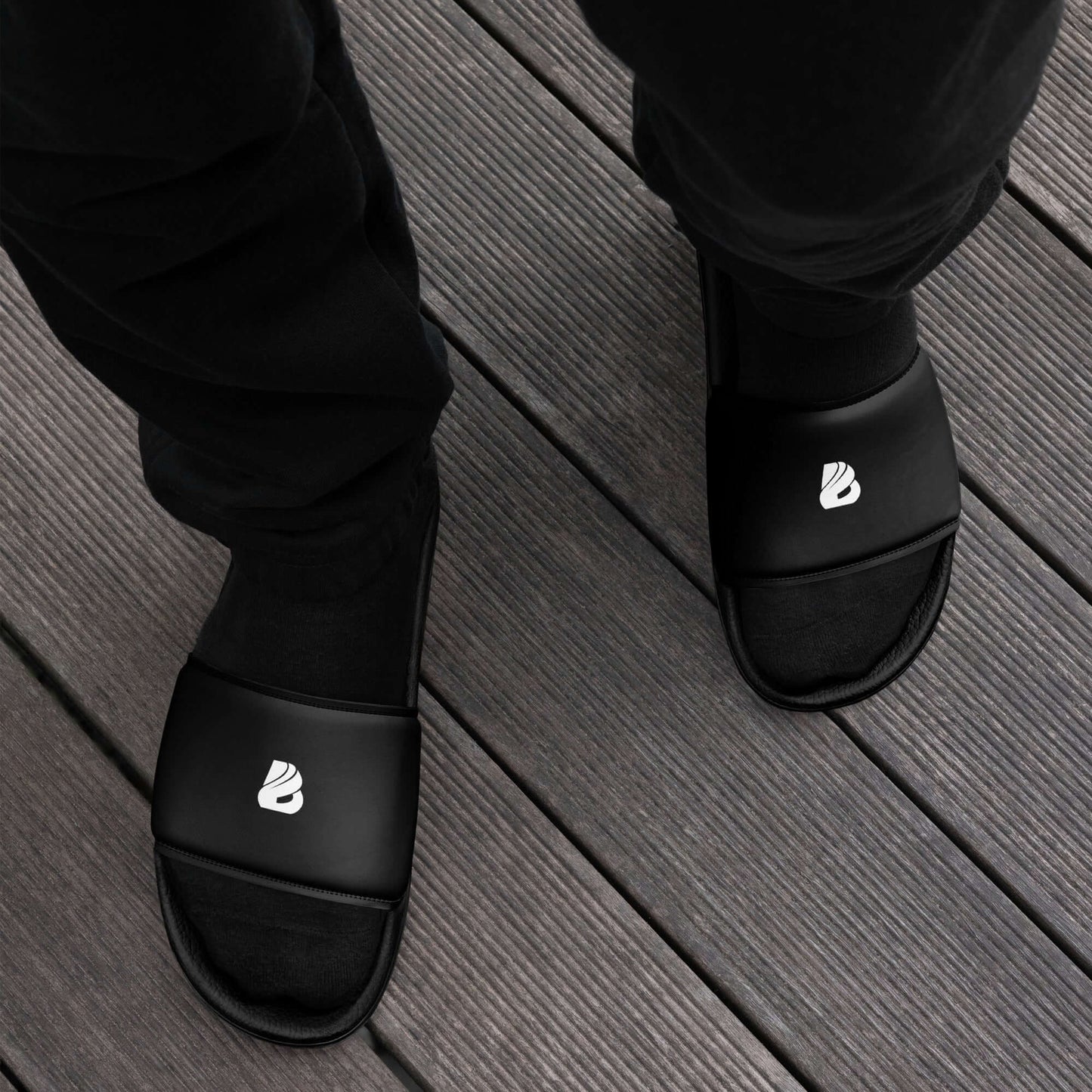 Herren-Schlappen N°1 black sandals with cushioned strap and textured footbed on wooden deck