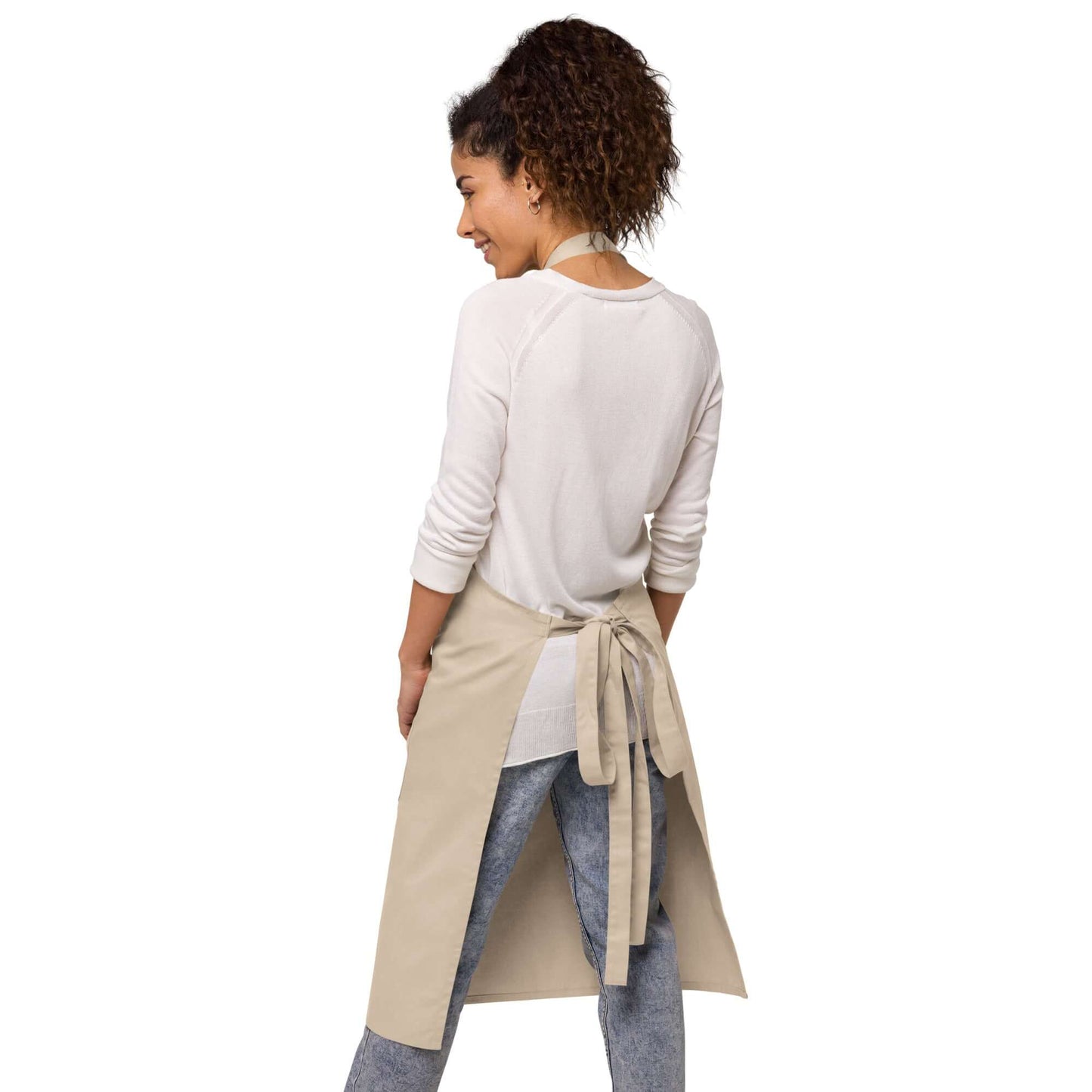 Model wearing Schürze aus Bio-Baumwolle N°0, showcasing adjustable straps and back view in kitchen setting.