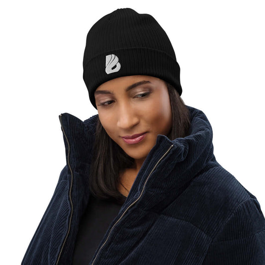 Woman wearing Gerippte Bio-Beanie N°0, stylish and eco-friendly, made of 100% organic cotton, ideal for indoor and outdoor use.