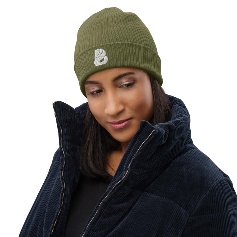 Person wearing a stylish olive Gerippte Bio-Beanie N°0, made of 100% organic cotton, with a breathable, lightweight fabric.