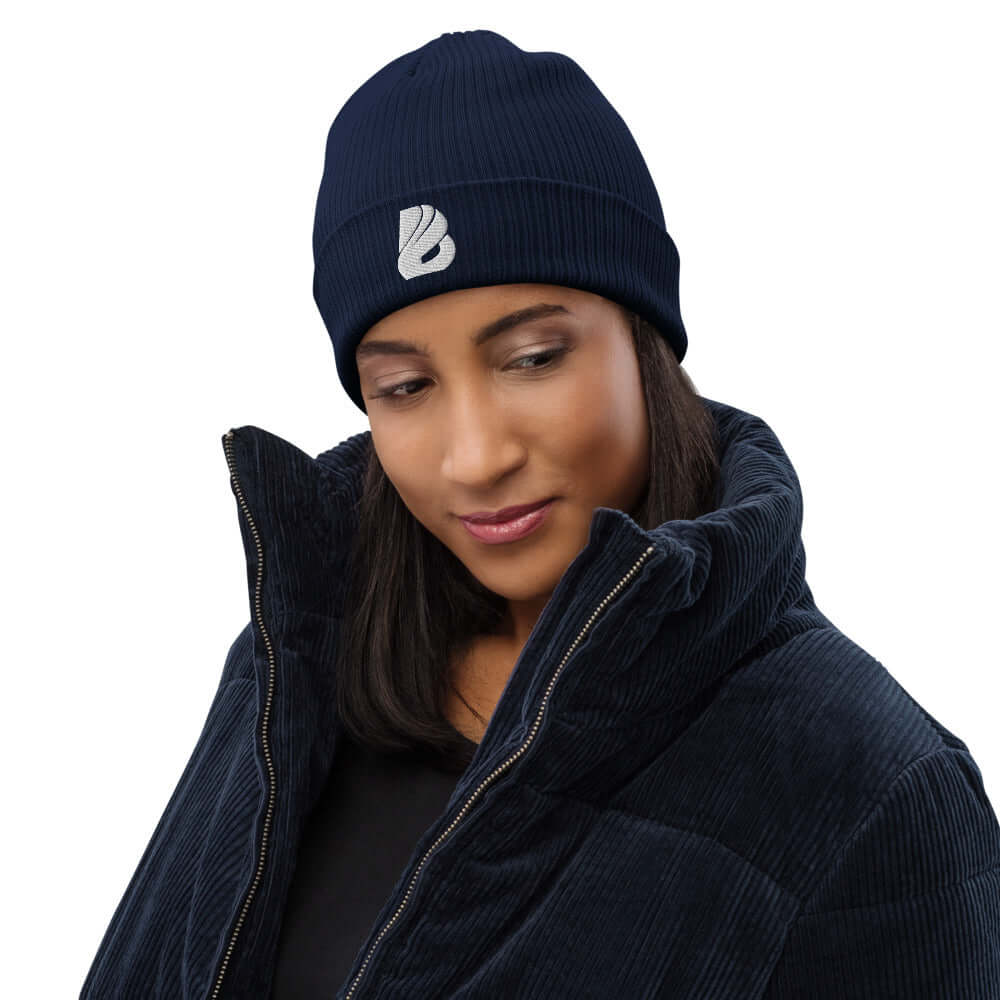 Frau trägt Gerippte Bio-Beanie N°0, stilvolle und umweltfreundliche Mütze aus 100% organischer Baumwolle, perfekt für drinnen und draußen.