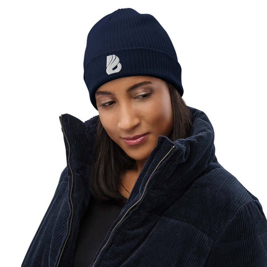 Frau trägt Gerippte Bio-Beanie N°0, stilvolle und umweltfreundliche Mütze aus 100% organischer Baumwolle, perfekt für drinnen und draußen.