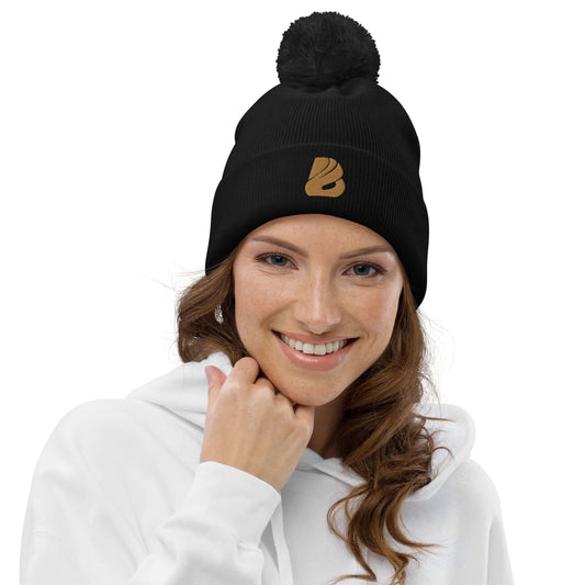 Woman wearing Bommel-Beanie N°0 in black with pom-pom and matching emblem, ideal for autumn and winter.