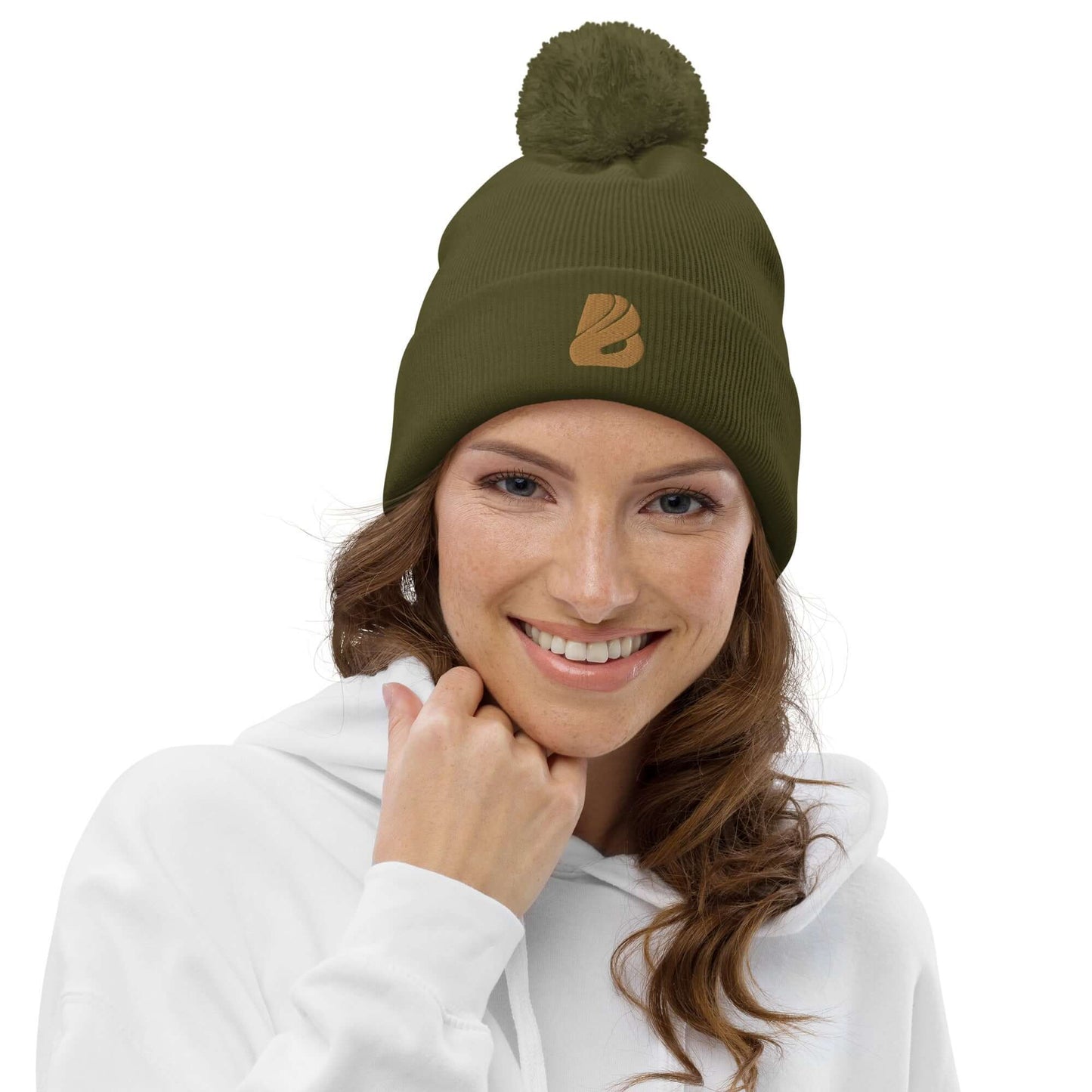 Woman smiling in olive Bommel-Beanie N°0 with pom-pom and branded logo, made from soft acrylic fiber for warmth and comfort.