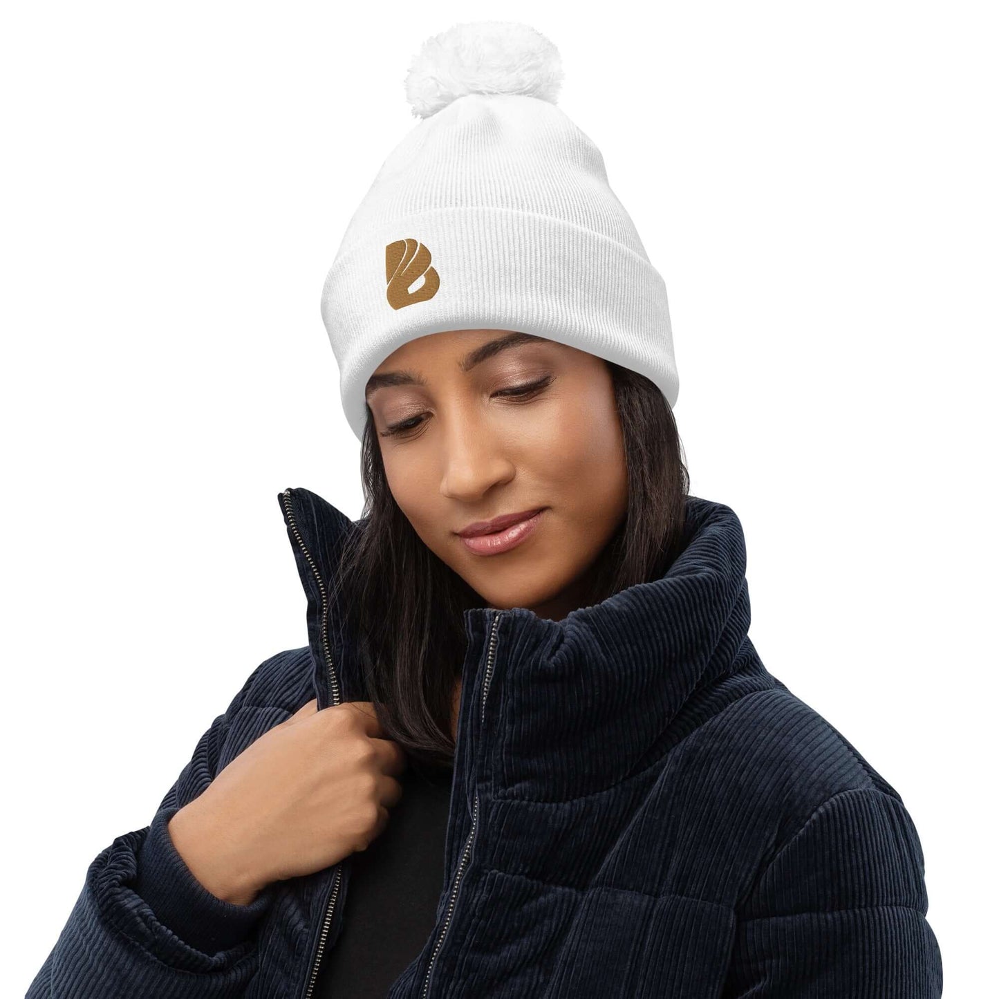 Woman wearing Bommel-Beanie N°0 in white with logo, showcasing cozy winter wear made from 100% soft acrylic for warmth.