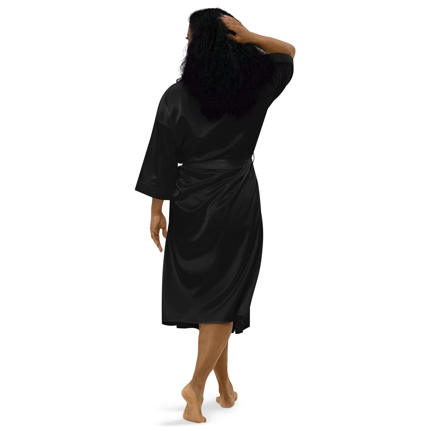 Woman wearing black Satinmantel N°2, showing back view with 3/4 sleeves and knee-length design, perfect for luxurious relaxation.