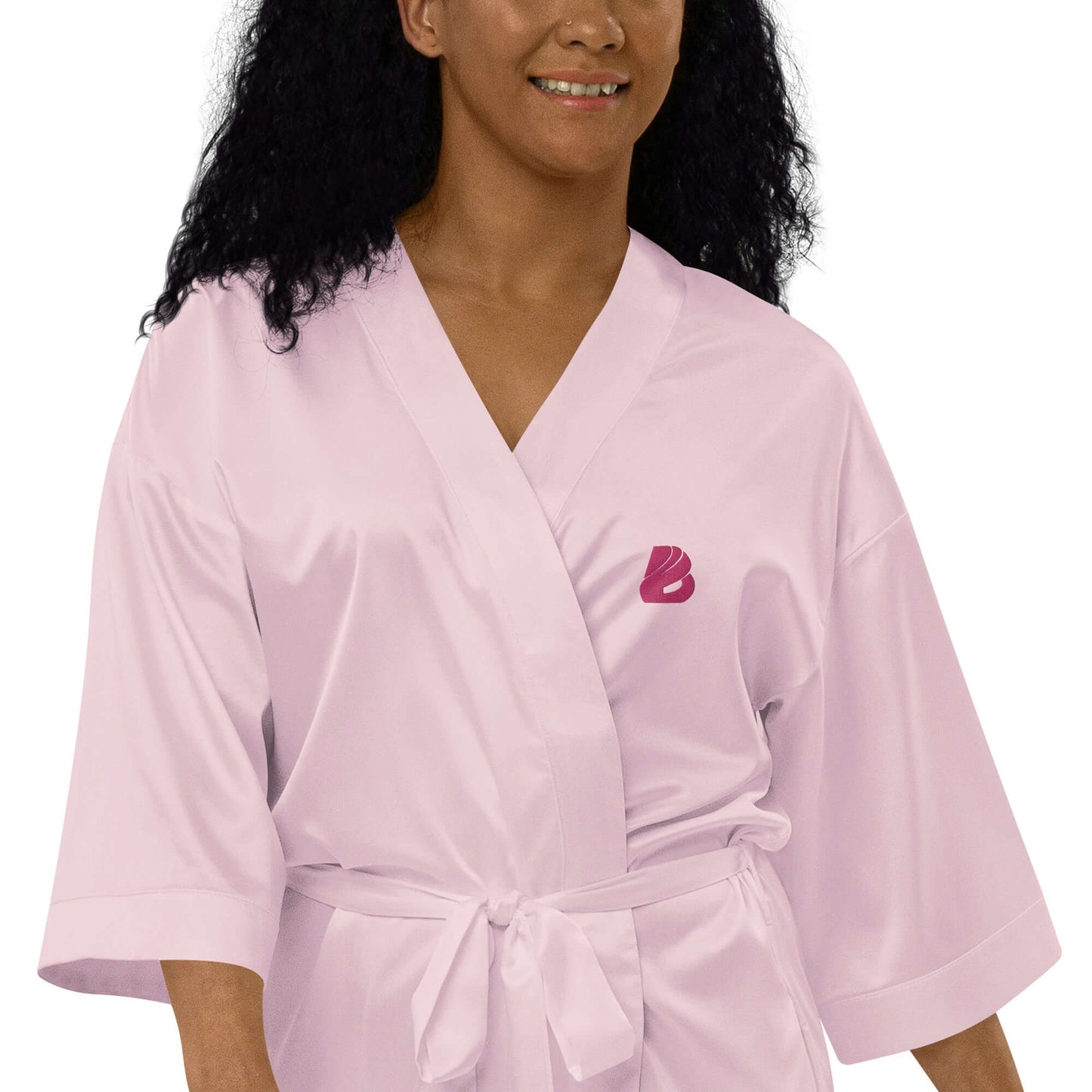 Woman wearing pink Satinmantel N°2 kimono-style robe with 3/4 sleeves, perfect for special occasions.