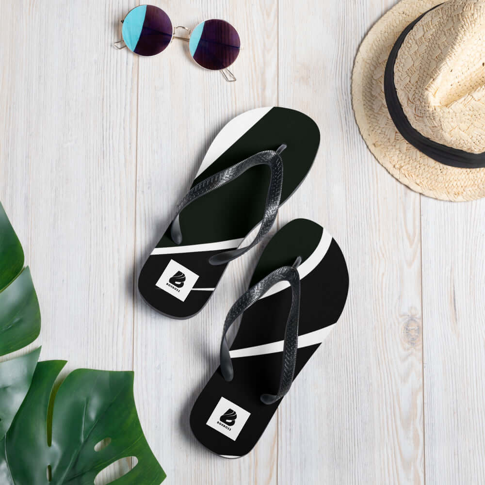 Alt Tag: Stylish Flip-Flops N°0 with black and white design on a wooden floor, perfect for summer adventures.