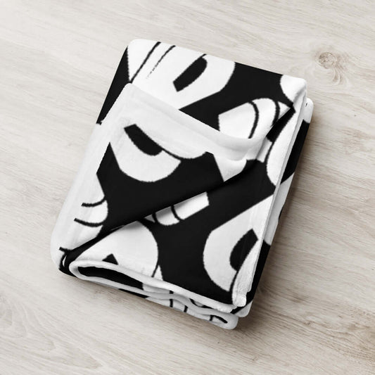 Folded black and white patterned Tagesdecke N°0 blanket, 100% polyester, soft silk-like fabric, hypoallergenic, machine washable.