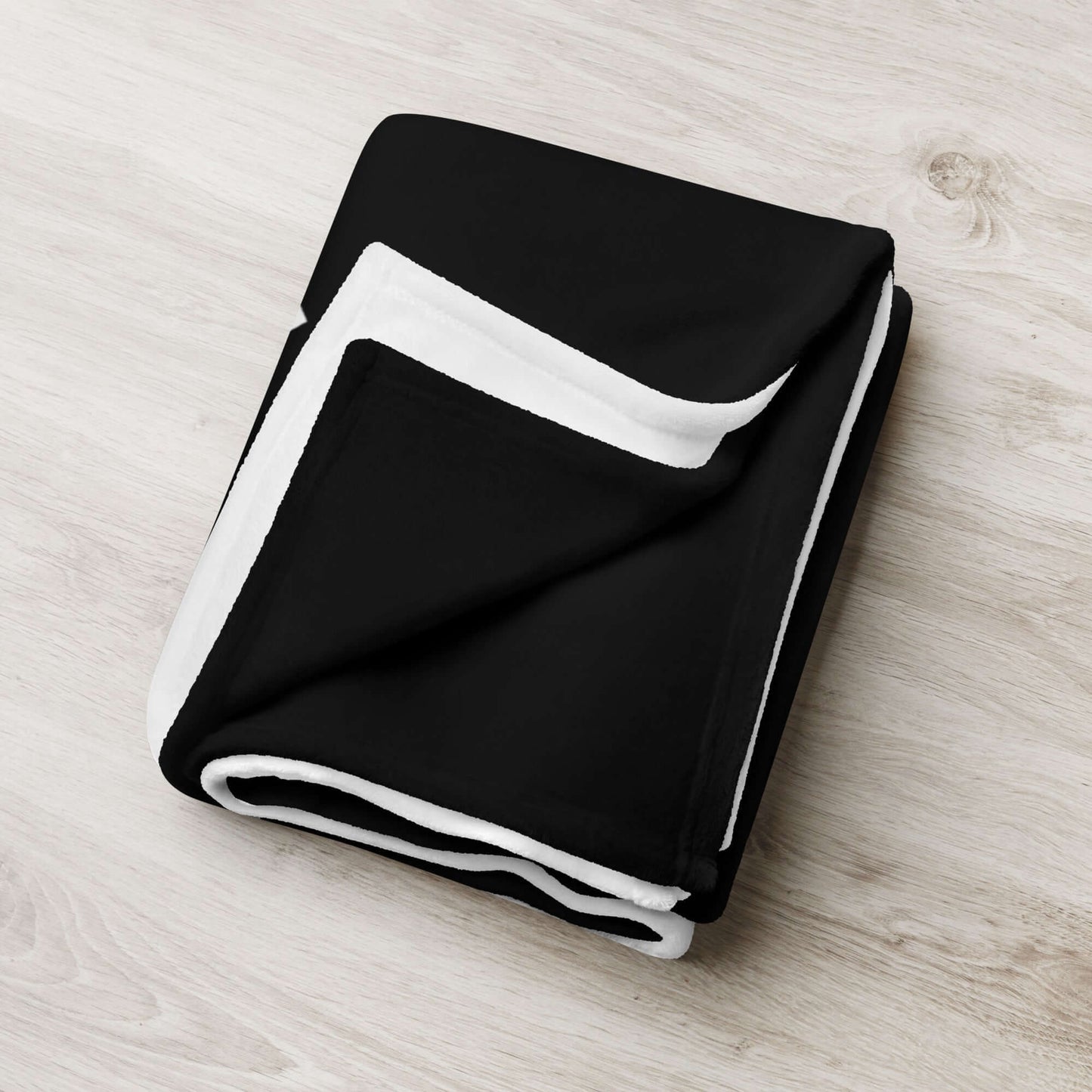 Black and white Tagesdecke on a wooden surface, soft polyester fabric, perfect for adding personality and comfort to your home.