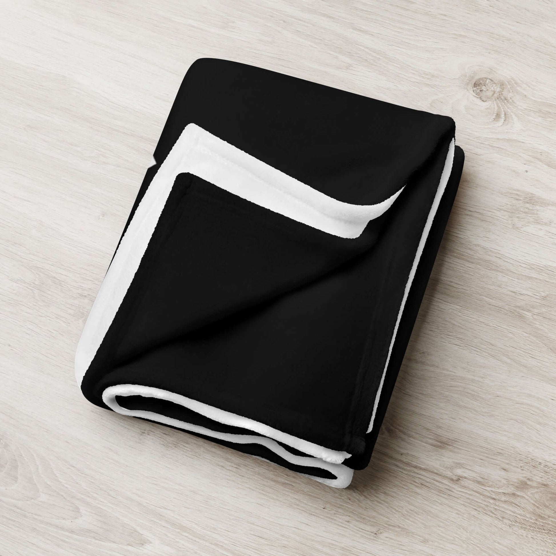 Black and white Tagesdecke on a wooden surface, soft polyester fabric, perfect for adding personality and comfort to your home.