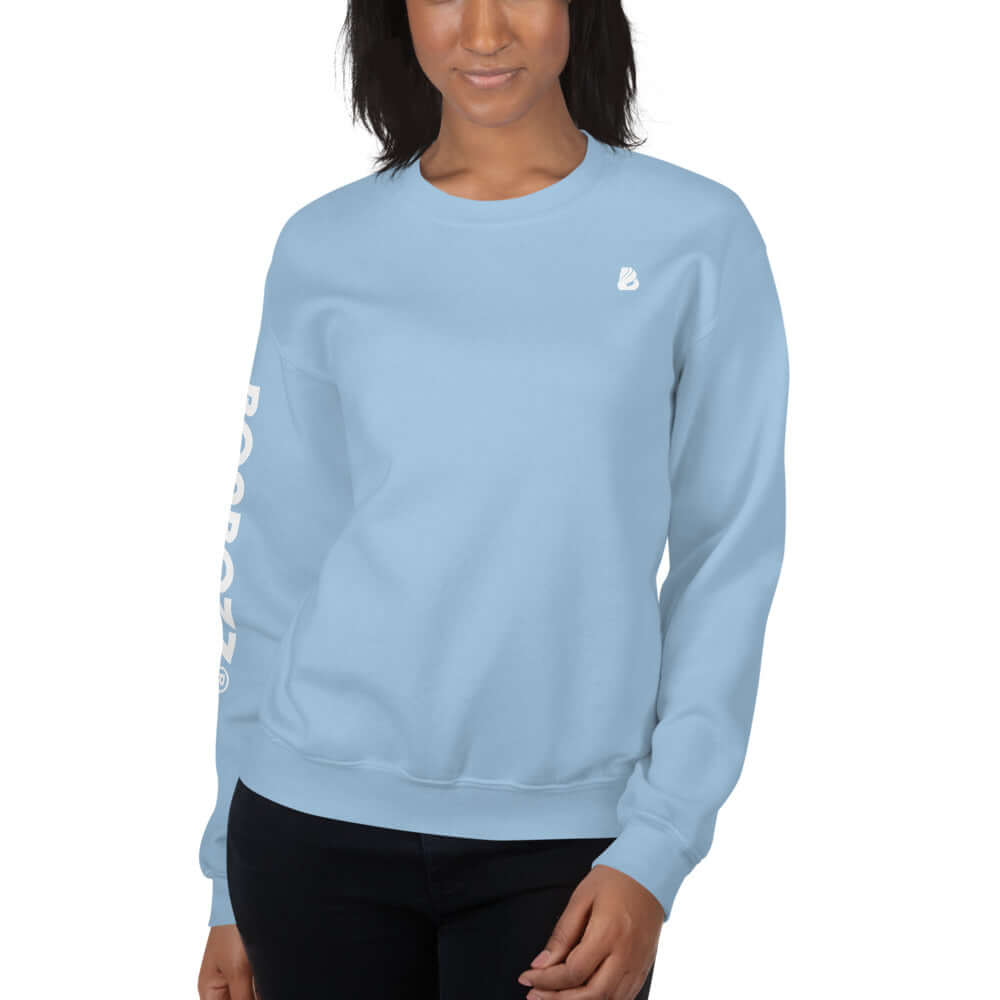 Woman wearing a light blue Unisex-Pullover N°13, showcasing its classic fit and ribbed details, made from soft, preshrunk cotton-polyester blend.