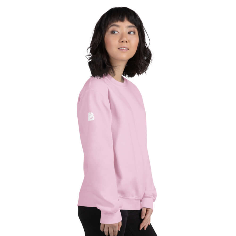Woman wearing pink Unisex-Pullover N°5, a durable and warm, pre-shrunk sweater made from air-jet spun yarn for a soft feel.