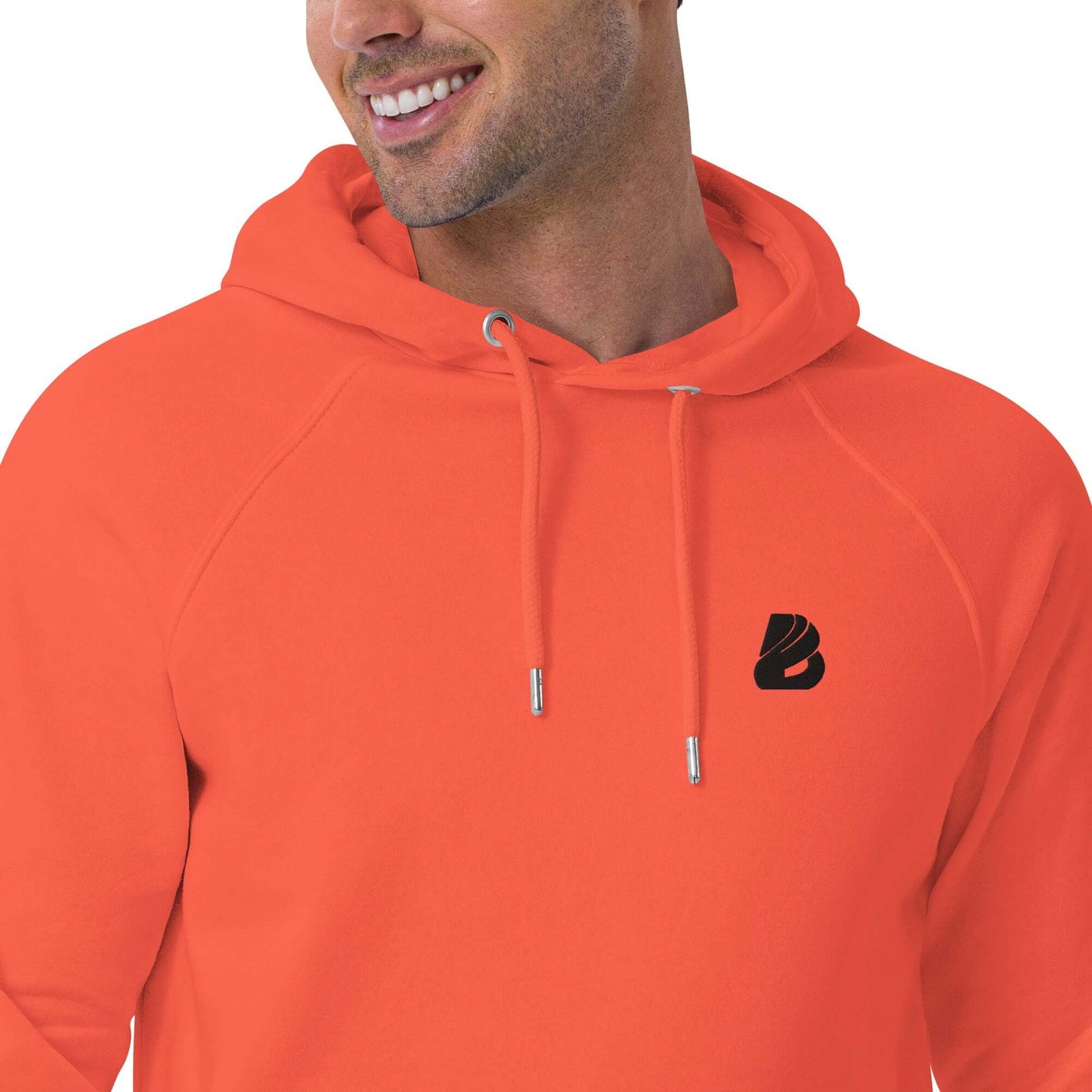 Model wearing Unisex Bio-Raglan-Hoodie N°1 in vibrant orange, highlighting soft comfort and stylish design with logo detail.