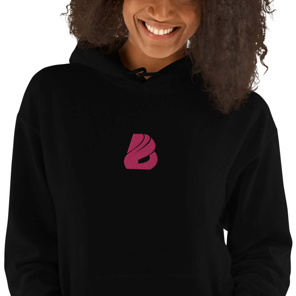 Unisex-Kapuzenpullover N°44 in schwarz, Modell trägt gemütlichen Hoodie mit rotem Logo, ideal für kühle Abende.