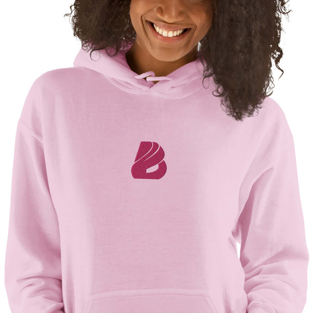 Woman wearing pink Unisex-Kapuzenpullover N°44 with cozy hood and stylish logo