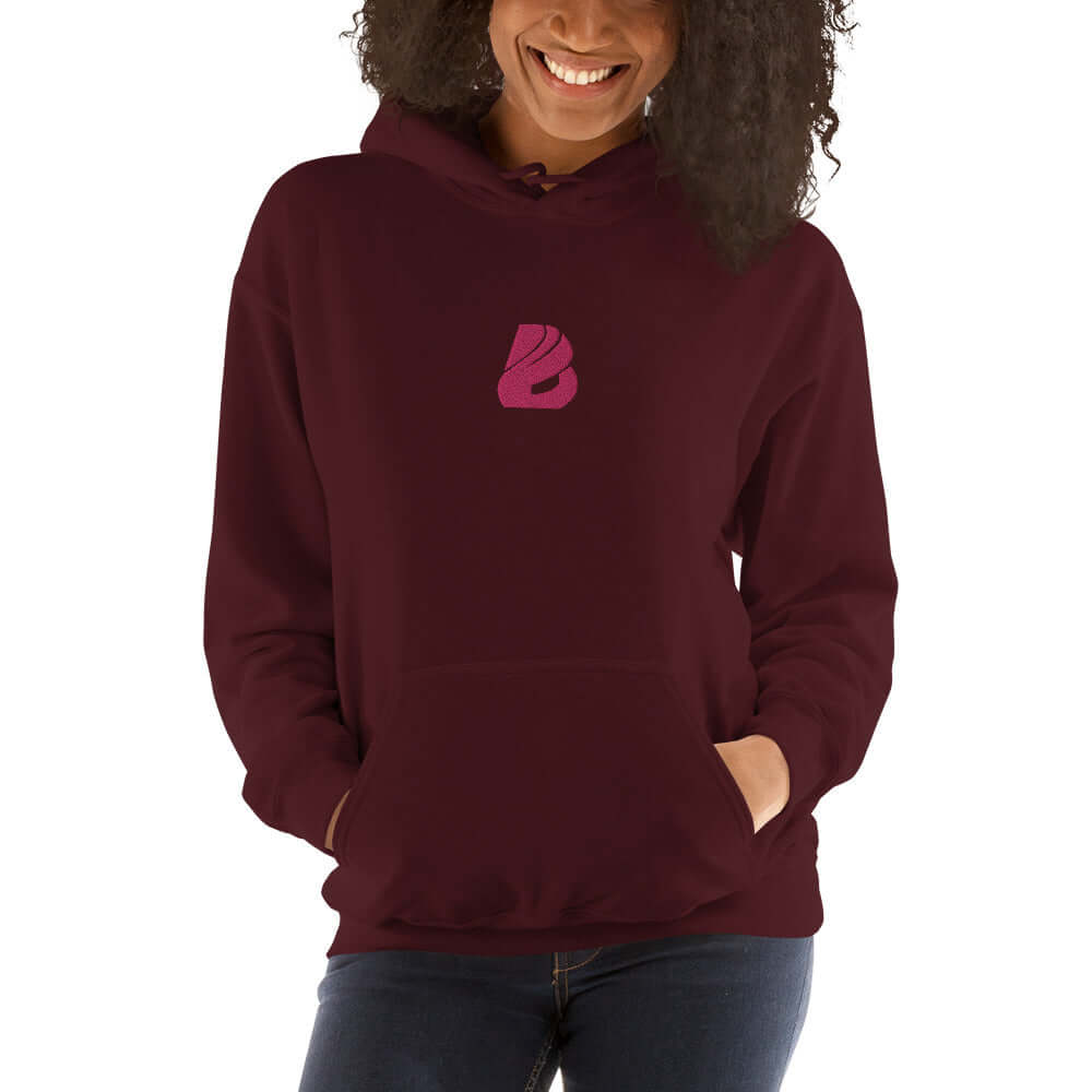 Cozy Unisex-Kapuzenpullover N°44 in burgundy with a stylish pink logo, perfect blend of softness and style for cool evenings.