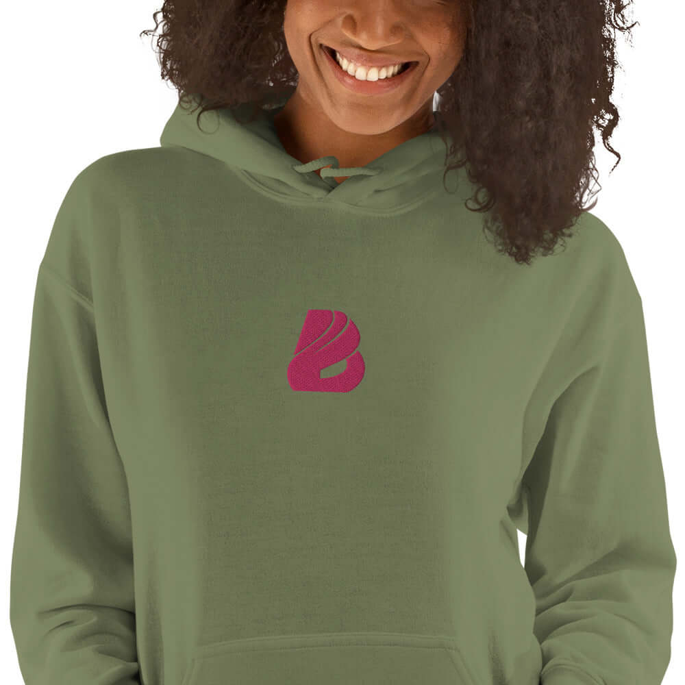Person wearing Unisex-Kapuzenpullover N°44 in green with purple logo, soft and stylish hoodie perfect for cool evenings.