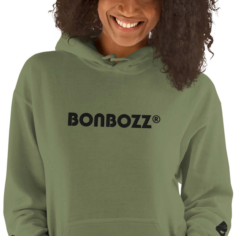 Woman wearing Unisex-Kapuzenpullover N°46 in green with "Bonbozz" logo, showcasing soft hood and stylish design