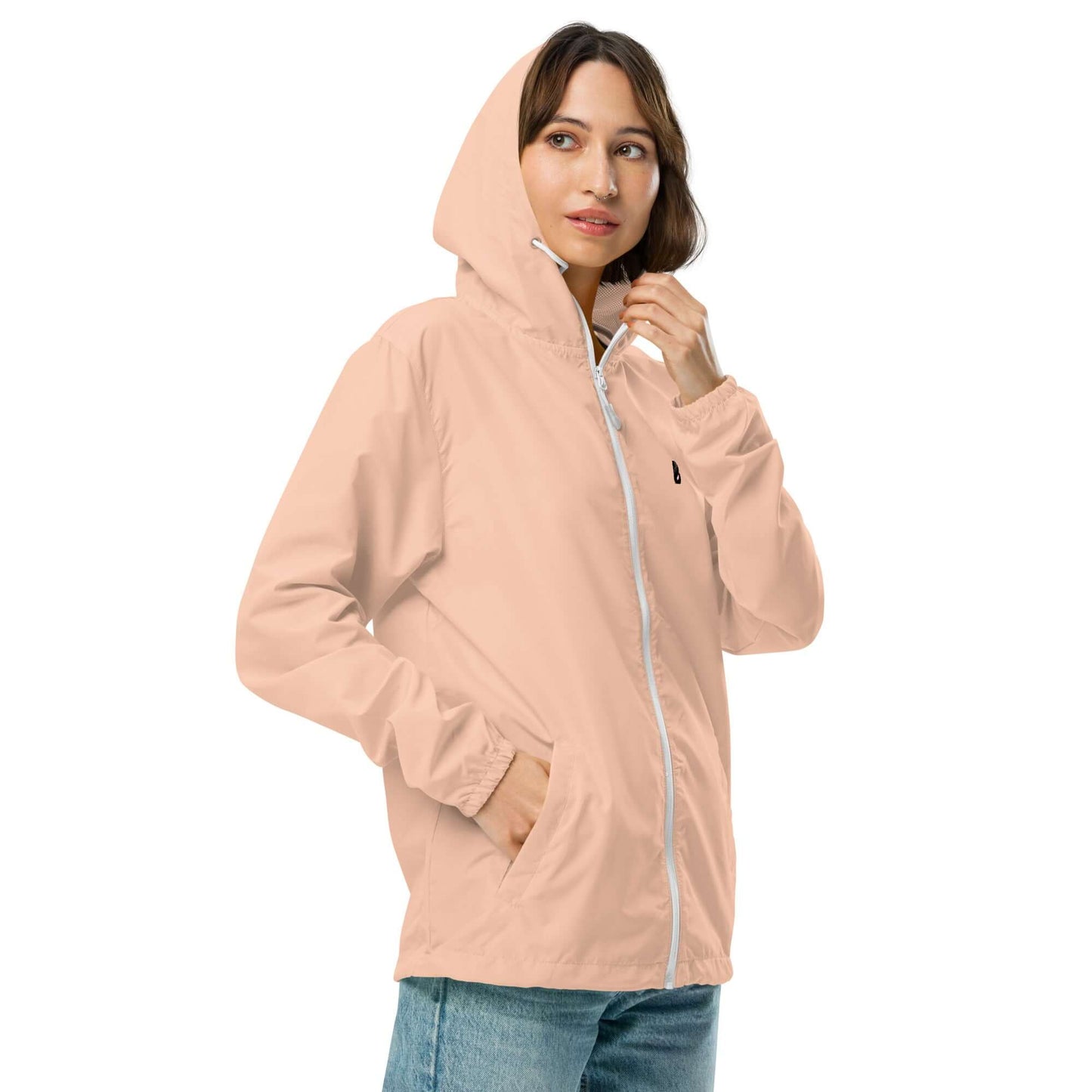 Person wearing Leichter Unisex-Windbreaker mit Reißverschluss N°0, lightweight, waterproof jacket in peach color, perfect for adventures.
