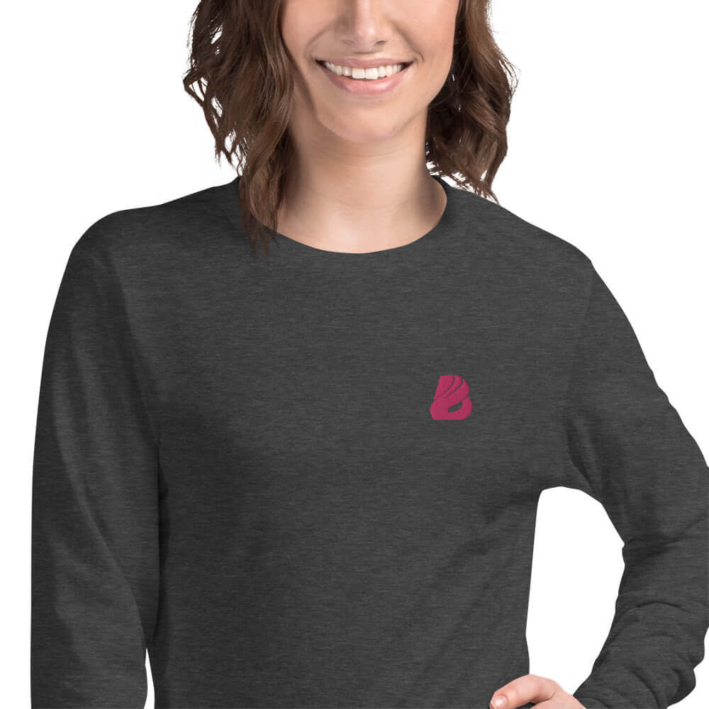 Langärmeliges Unisex-T-Shirt N°0 in dark grey worn by a model, showcasing the front logo. Versatile for casual and professional attire.