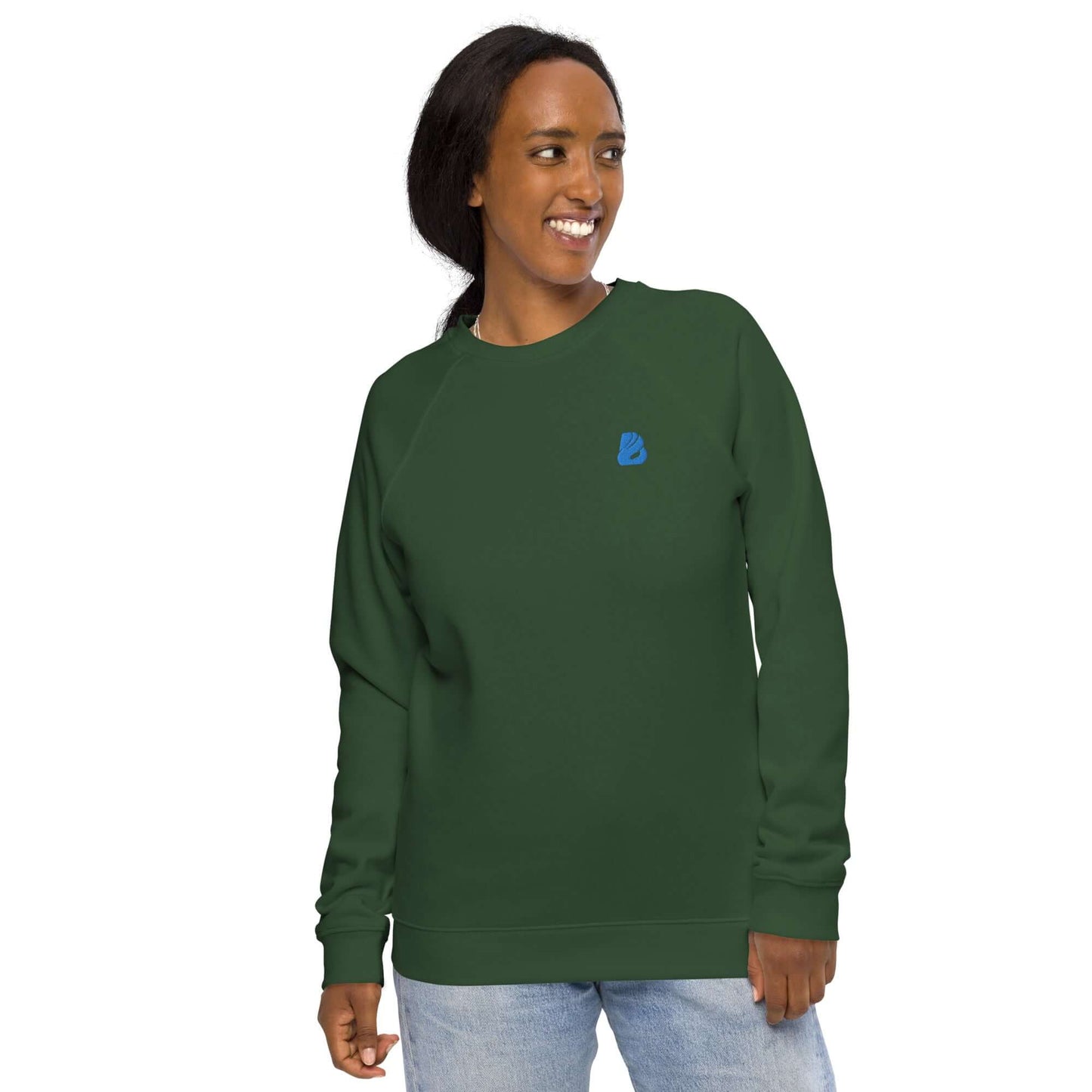 Woman wearing Unisex Bio-Raglan-Pullover N°1 in green, smiling comfortably in stylish casual outfit.