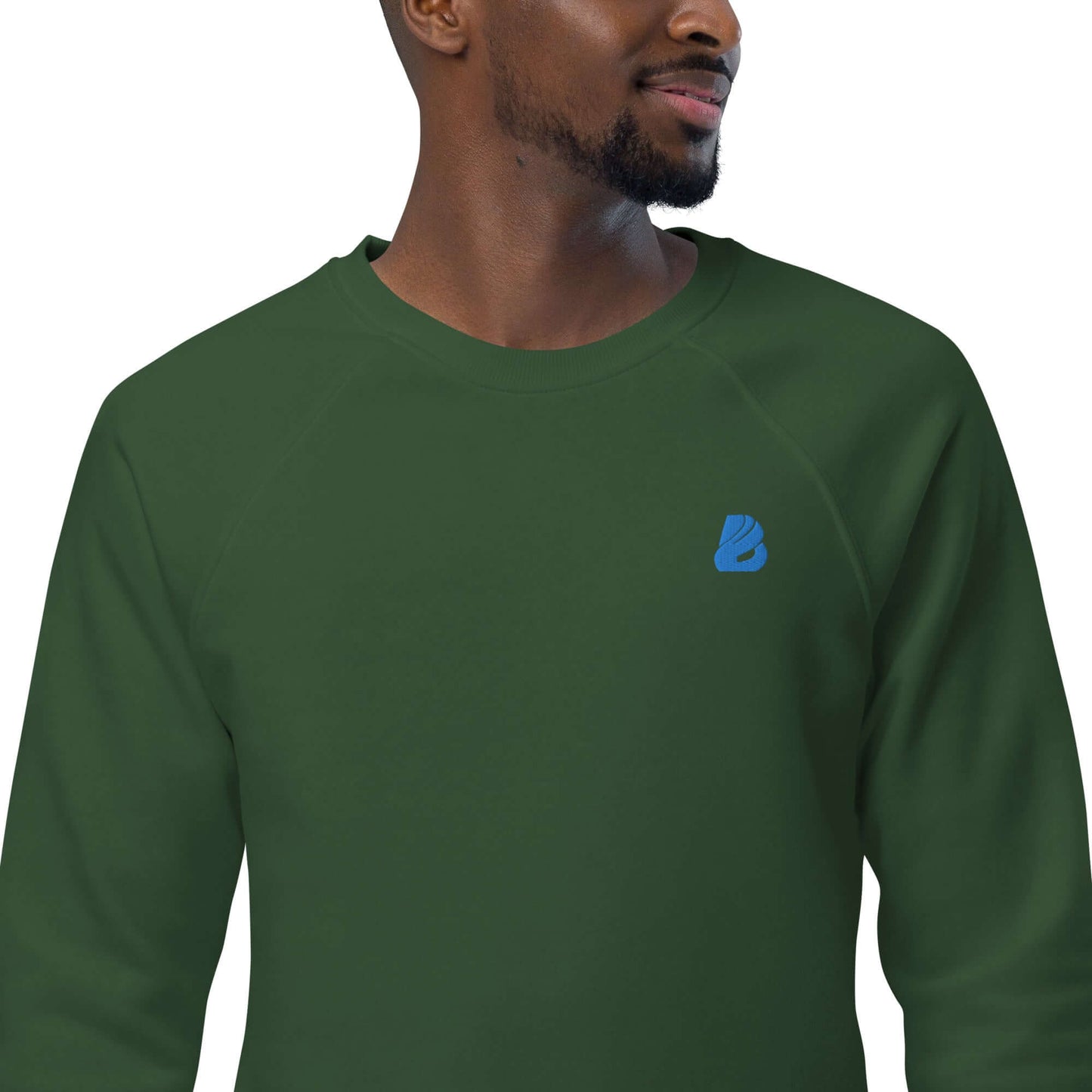 Model wearing Unisex Bio-Raglan-Pullover N°1 in green with blue logo, showcasing stylish comfort and soft organic cotton fleece.