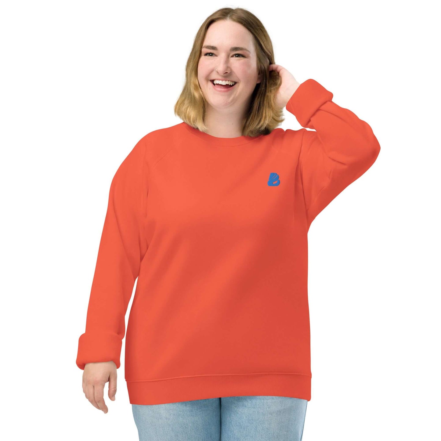 Smiling person wearing Unisex Bio-Raglan-Pullover N°1 in vibrant orange, showcasing stylish comfort with eco-friendly materials.