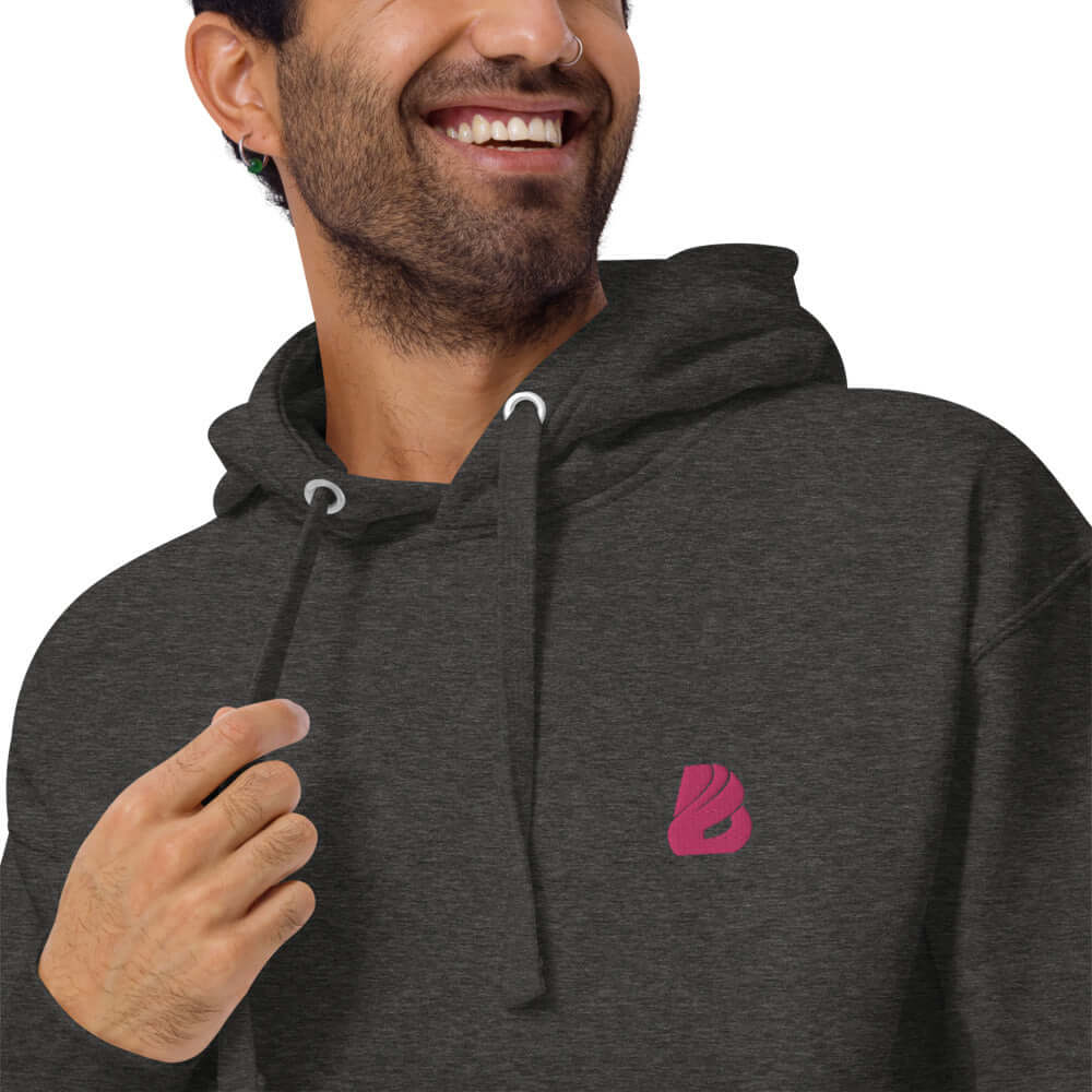 Smiling person wearing Unisex-Kapuzenpullover N°22 with kangaroo pocket and stylish hood.