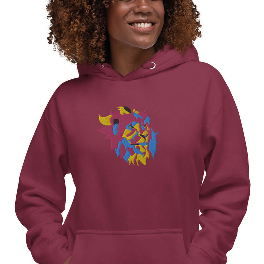 Unisex-Kapuzenpullover N°40 in burgundy with artistic vibrant design, featuring kangaroo pocket and hood on a smiling model.